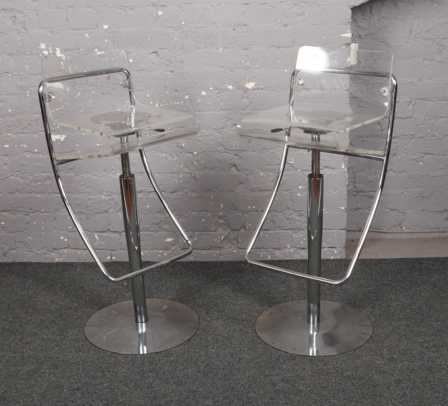 Two bar chairs, with chrome supports and clear perspex seats.