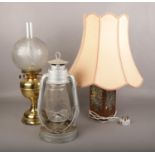 A brass oil lamp, along with a Tornado lamp and a copper table lamp.