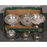 A box of silver plate to include teapot, tray raised on four claw feet etc.