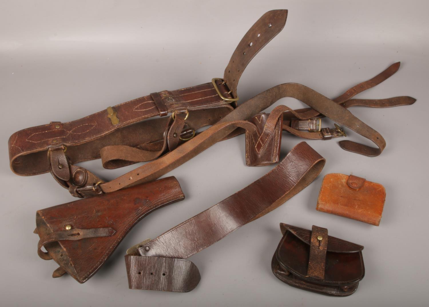 A collection of WWI leather to include gun holster, belt, purses etc.