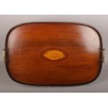An Edwardian mahogany serving tray with inlaid shell patera and brass handles, 57cm wide.