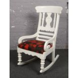 A white painted Victorian rocking chair with William Morris style upholstered seat.