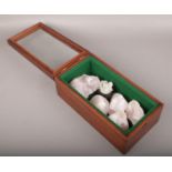 A mahogany and glass display case with contents of rose quartz crystals.