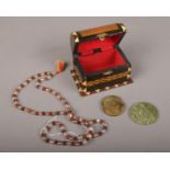 A wooden box containing two carved Jade discs & Sandlewood/rock crystal Tibetan prayer beads