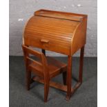 A child's swallow wooden roll top desk and chair.