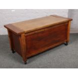 A wooden blanket box with square cut supports.