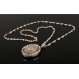 A silver locket on silver twist chain necklace.