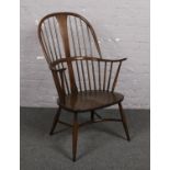 An Ercol Windsor arm chair with crinoline stretcher. Wear to one spindle. Slight wear to arm.