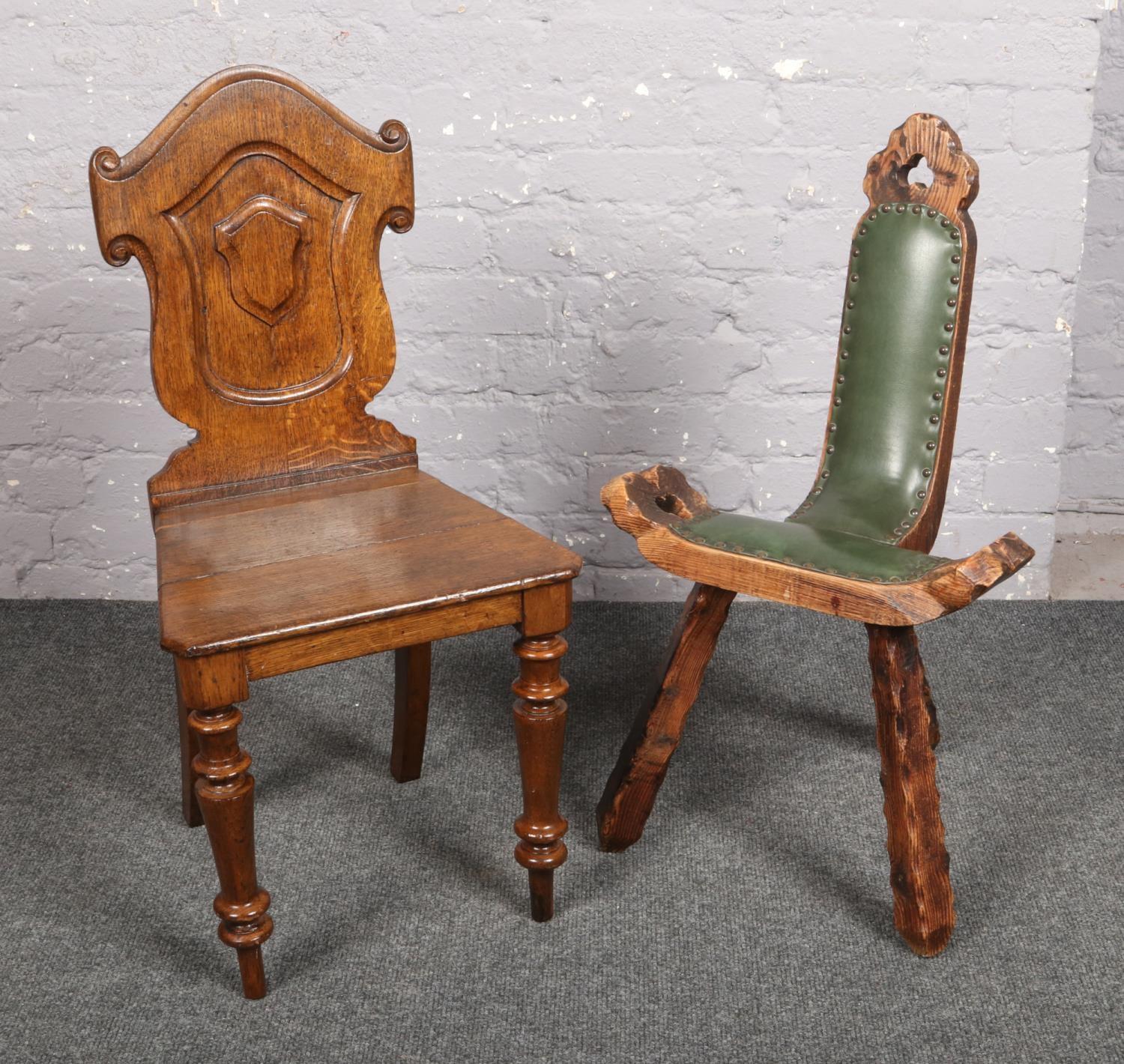A carved oak hall chair, along with an oak and leather three legged spinning chair. Hall chair