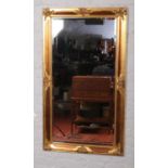 A large bevel edged hall mirror with gilt frame embellished with bronzed trellis panels, 138cm x