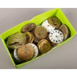 A box of pocket watch movements and dials.