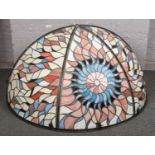 A large Tiffany style half hemispherical stage light shade. Decorated with a central sunburst motif,