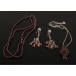 A suite of garnet and silver jewellery. Comprising a brooch / pendant on chain, beads and a pair