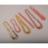 A collection of coral, amber and hardstone necklaces.