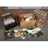 A box of kitchenalia and miscellaneous, two wine racks and a carry case of LP records.