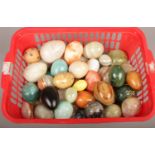 A basket of assorted carved and polished hardstone eggs.