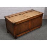 A carved and panelled oak blanket box.