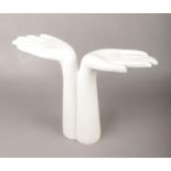 A decorative composite stand, formed as a pair of hands.