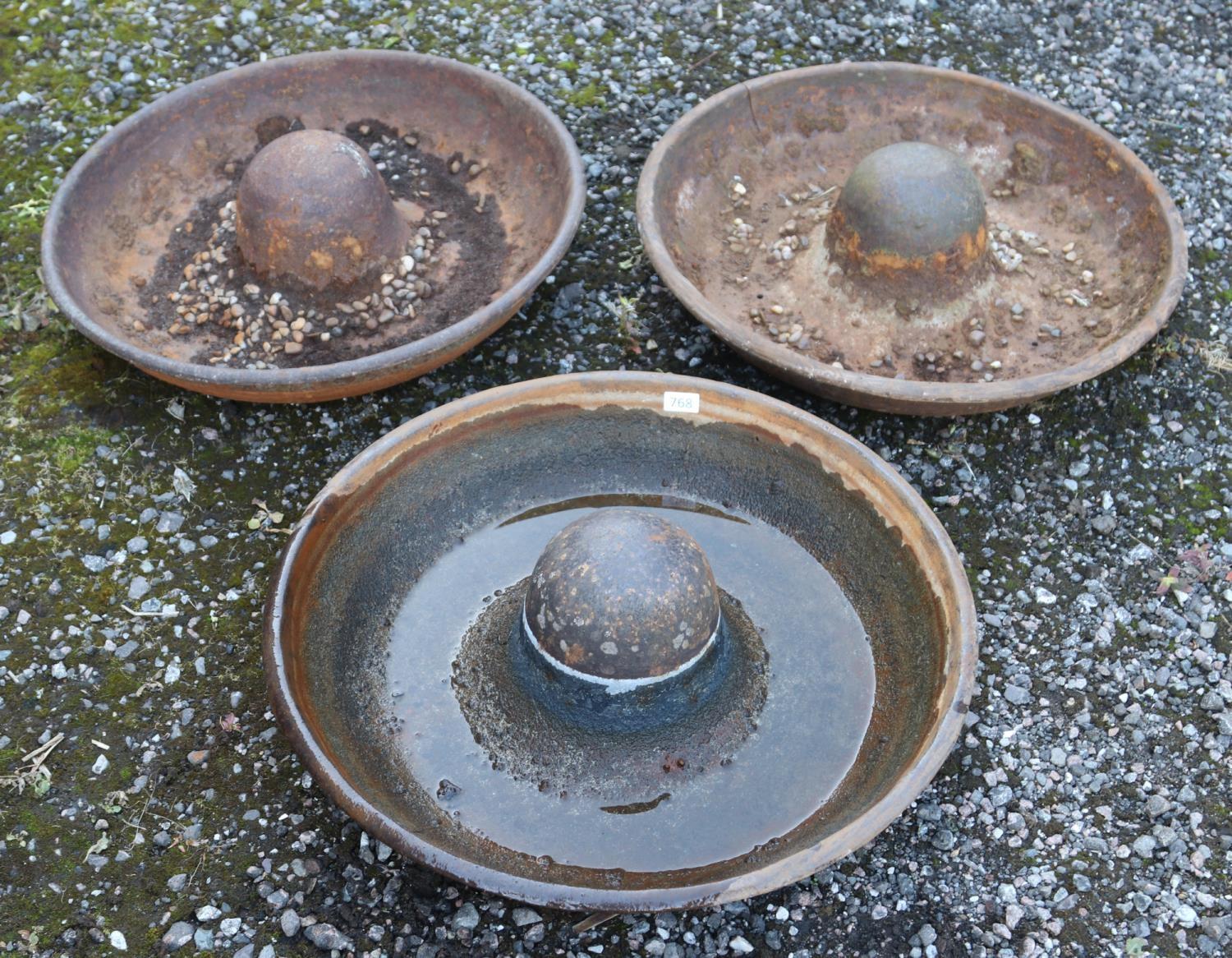 Three small Mexican hat shaped cast iron troughs.
