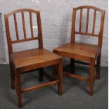 A pair of oak slat back chairs.