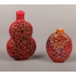 An oriental Cinnabar snuff bottle & Amber snuff bottle with missing stopper.