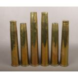 Six brass artillery shell casings.