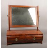 A Victorian mahogany two drawer toilet mirror with strung inlay and raised on ogee bracket feet.