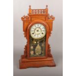 A carved mahogany Gingerbread clock. Scratches to dial.
