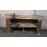 A vintage wooden work bench with vice.