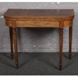 A Victorian inlaid mahogany fold over card table. Tired condition.