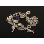 A silver charm bracelet. With enamel charms and heart shaped clasp.