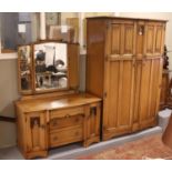 A three part oak bedroom suite with linen fold decoration, including double wardrobe, dressing table