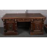 A large and impressive Victorian Gothic revival heavily carved oak partners desk with carved lion