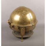 A brass globular formed food warmer raised on scroll supports.