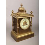 A brass mantle clock with column supports, chiming on a coiled gong. Crack to dial. Door slightly