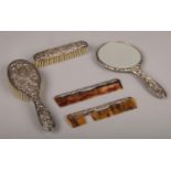 A Silver engraved detailing bedroom set, hairbrush, clothes brush, combs, hand mirror. some teeth