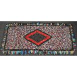 A handwoven peg rug with central diamond design. (145cm x 70cm).