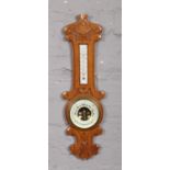 A carved oak cased banjo wall barometer of small proportions, 57cm. Good condition.
