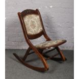 An early 20th century carved folding rocking chair.