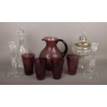 A collection of glassware including a pair of lead crystal candlesticks and an amethyst glass