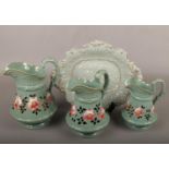 A set of three 19th century Ridgway graduated green stoneware jugs painted with flowers and a