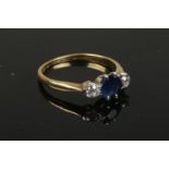 An 18ct gold and platinum three stone sapphire and diamond ring. Central sapphire 0.7ct and a pair