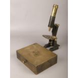 An antique lock box, along with a brass and steel microscope.