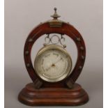 A barometer in cylinder case supported on a horse shoe stand with metal mounts. Maker Curtis of