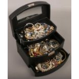 A three tier jewellery box of costume jewellery to include beads, bangles, necklaces, bracelets,