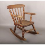 A child's oak spindle back rocking chair.