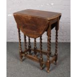 A small oak drop leaf table with barley twist supports.