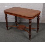 A Victorian mahogany side table with cross stretcher and turned supports.