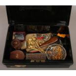 A tin cash box containing collectables including Navy brass buttons, Royal Scots cap badge,