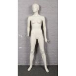 A shop mannequin of female form. Missing hand.